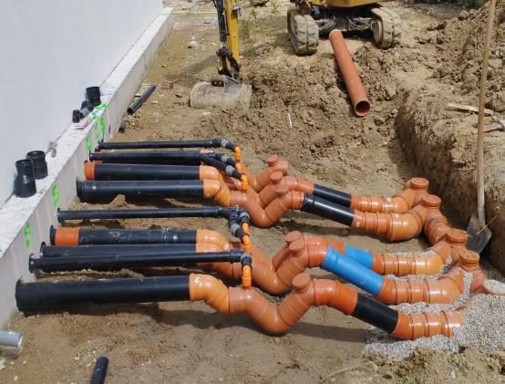 Posa di tubazioni di scarico lungo un edificio